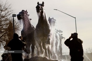 تصویر برداری مردم از یک بنای یادبود پوشیده از یخ در سیوداد خوارز، مکزیک