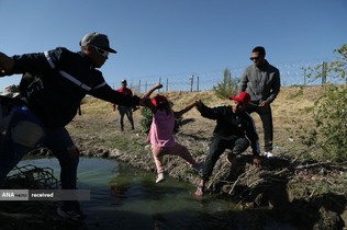 عبور مهاجران مکزیکی از رودخانه ای در مرز آمریکا
