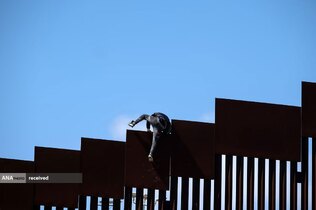 عبور یک مهاجر از حصار مرزی آمریکا و مکزیک