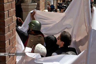 عمران خان نخست وزیر سابق پاکستان و همسرش هنگام ورود به دادگاه عالی در لاهور پاکستان با ملحفه سفید پوشانده شده اند.