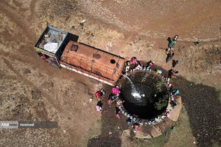نمایی از تانکری در نزدیکی بمبئی هند که آب را به داخل چاهی تخلیه می&zwnj;کند و زنان از آن آب می&zwnj;کشند.