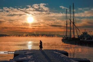 یک گردشگر در حین غروب آفتاب در اسلو، نروژ