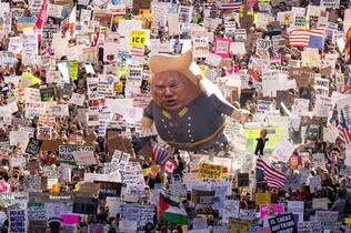 معترضان تابلوها، پرچم&zwnj;ها و بالون بزرگی با تصویر دونالد ترامپ را در یک تظاهرات سراسری &laquo;دست&zwnj;های آوار&raquo; در مرکز شهر لس&zwnj;آنجلس حمل می&zwnj;کنند.