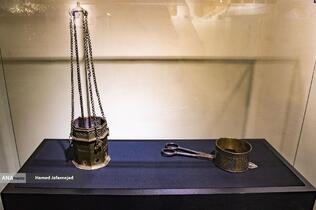 اسپنددودکن از جنس برنج دارای کتیبه وقف نامه و گُل گیر شمع مشبک و طلاکوب در اواخر دوره صفوی - نمایشگاه آثار منتخب گنجینه آستان قدس رضوی