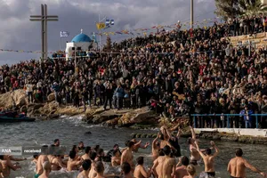 پرش مومنان ارتدکس برای گرفتن یک صلیب چوبی در رودخانه همزمان با جشن میلاد عیسی مسیح(ع) در پیرئوس، یونان