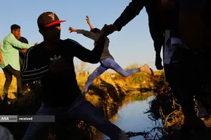 عبور مهاجران مکزیکی از رودخانه ای در مرز آمریکا