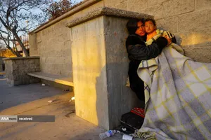 مهاجر مکزیکی و فرزندش که از آتش&zwnj;سوزی در کمپ مهاجران نجات یافت