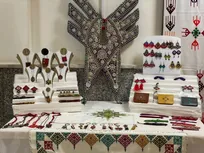 سوزن‌دوزی فاخر زنان بلوچ با حجاب و عفاف در جوار عکس شهدا